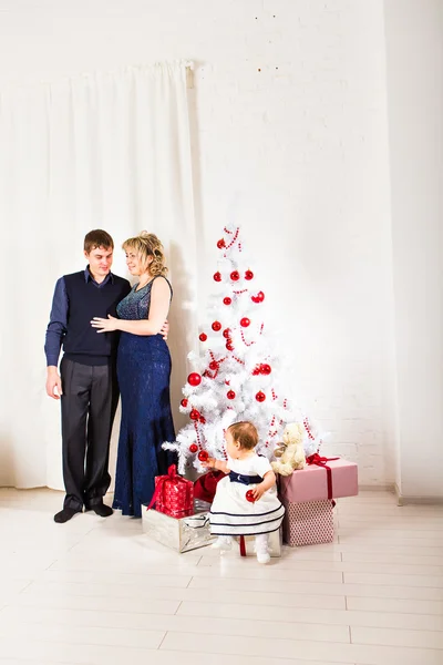 Familia de Navidad de tres personas y abeto con cajas de regalo —  Fotos de Stock