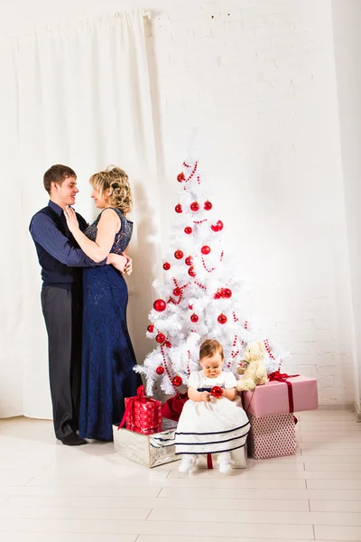 Família de Natal de três pessoas e abeto com caixas de presente — Fotografia de Stock