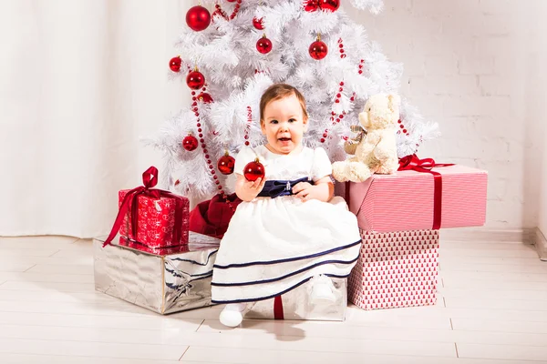 Menina pequena feliz jogando perto da árvore de Natal — Fotografia de Stock