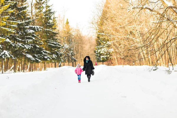 Moeder met haar dochter in winter park — Stockfoto