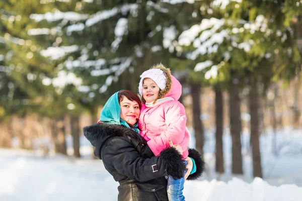 Família feliz mãe e bebê filhinha brincando no parque de inverno. Férias de Natal — Fotografia de Stock