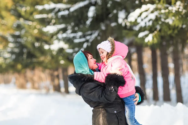 Happy family mother and baby little daughter playing in the winter park. Christmas holidays — Stock Photo, Image