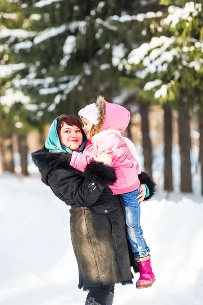 Happy family mother and baby little daughter playing in the winter park. Christmas holidays — Stock Photo, Image