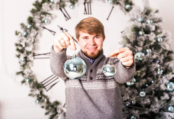 Navidad, decoración, vacaciones y concepto de la gente - primer plano del hombre sosteniendo la bola de Navidad —  Fotos de Stock