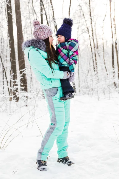 Happy family mother and child baby daughter on a winter walk in the woods — Stock Photo, Image