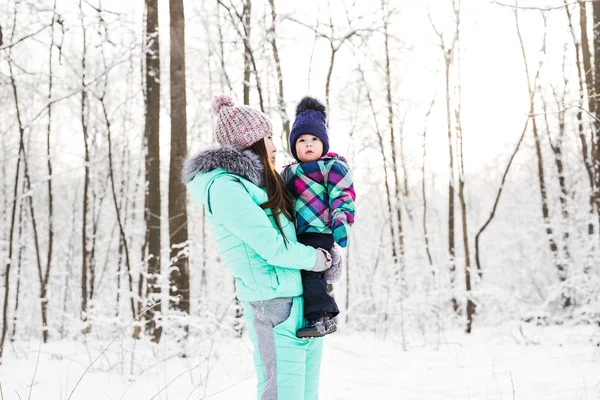 Happy family mother and child baby daughter on a winter walk in the woods — Stock Photo, Image