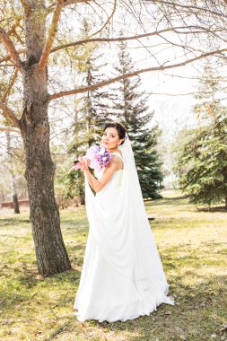 doğa akan bir perde ile parkta genç esmer gelin.