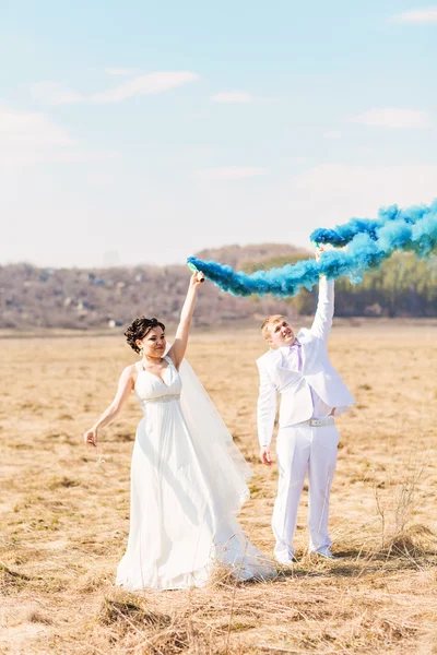 Para ślub z niebieskiego dymu w parku — Zdjęcie stockowe