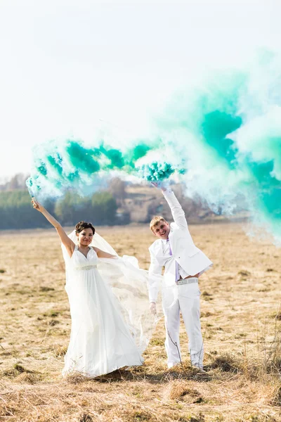 Pareja de boda con humo azul en el parque —  Fotos de Stock