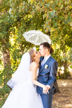 Sadece evli çift beyaz şemsiye tutan