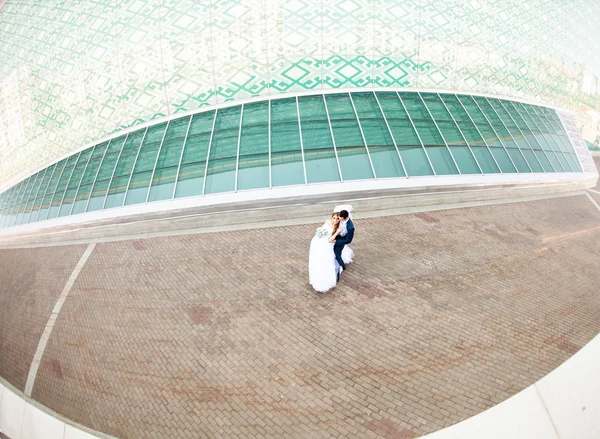 Pareja de bodas caminando entre las casas y los edificios —  Fotos de Stock