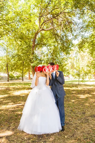 Casamento casal de mãos dadas na palavra amor — Fotografia de Stock