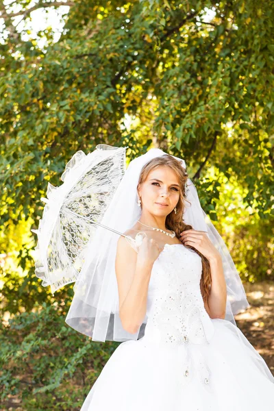 Wunderschöne Braut mit stylischem Make-up im weißen Kleid — Stockfoto