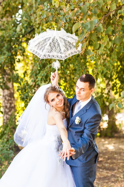 Just married couple holding white umbrella — Stock Photo, Image