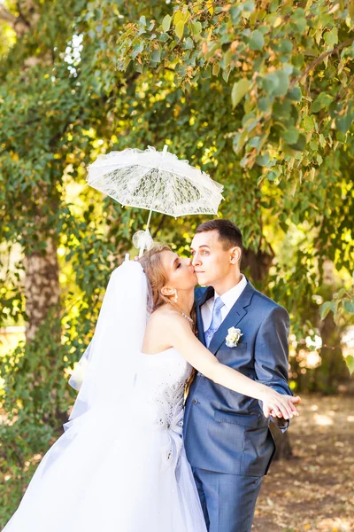 Casado casal segurando guarda-chuva branco — Fotografia de Stock