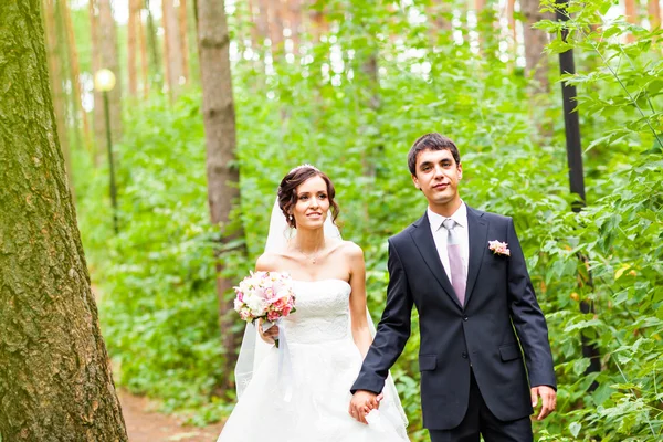 Novia y novio en un parque. vestido de novia. Ramo de flores nupcial — Foto de Stock