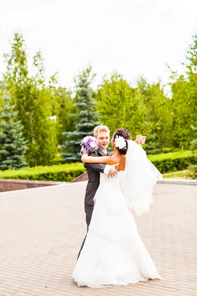 Groom holding bride in dance pose on wedding day — Stock Photo, Image