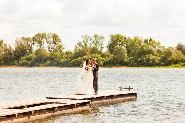 Casal de casamento perto de água — Fotografia de Stock