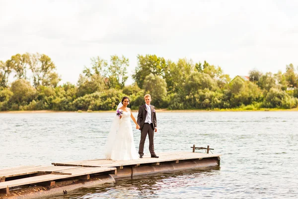 Casal de casamento perto de água — Fotografia de Stock