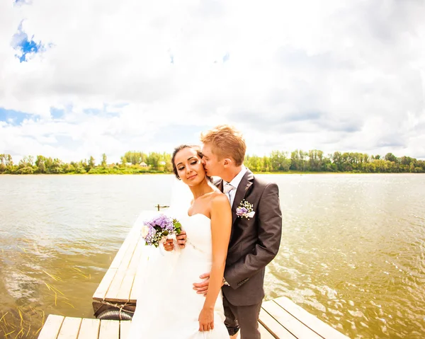 Casal de casamento perto de água — Fotografia de Stock