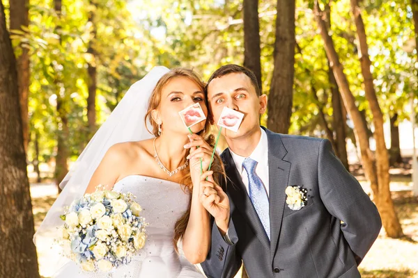 Matrimonio coppia posa con labbra bastone, maschera — Foto Stock