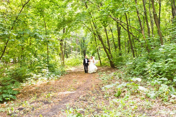 Νύφη και γαμπρός στο γάμο ημέρα περπάτημα σε εξωτερικούς χώρους — Φωτογραφία Αρχείου