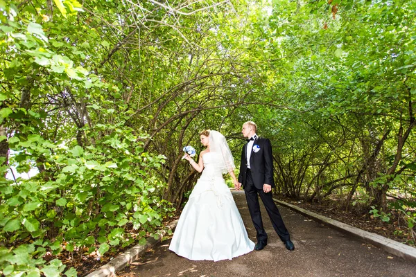 Elegáns menyasszony és vőlegény pózolnak együtt a szabadban egy esküvő napján. — Stock Fotó