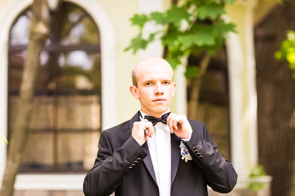 El novio sostiene una corbata y sonríe . — Foto de Stock