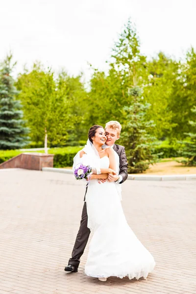 Schönes Hochzeitspaar im Park. Kuss und Umarmung — Stockfoto