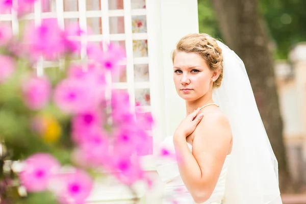 Mooie bruid met stijlvolle make-up in witte jurk — Stockfoto