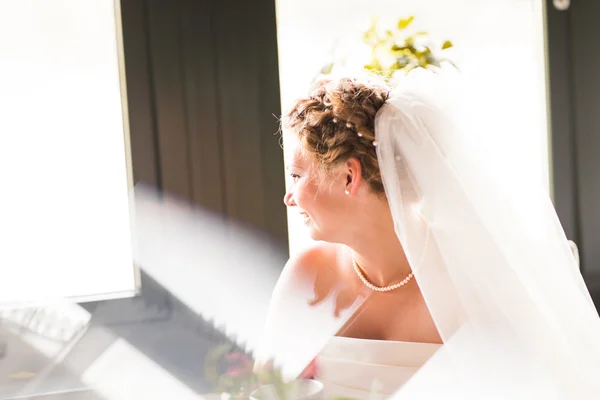 Mooie bruid met stijlvolle make-up in witte jurk — Stockfoto