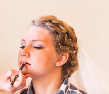 stylist maakt make-up bruid op de huwelijksdag