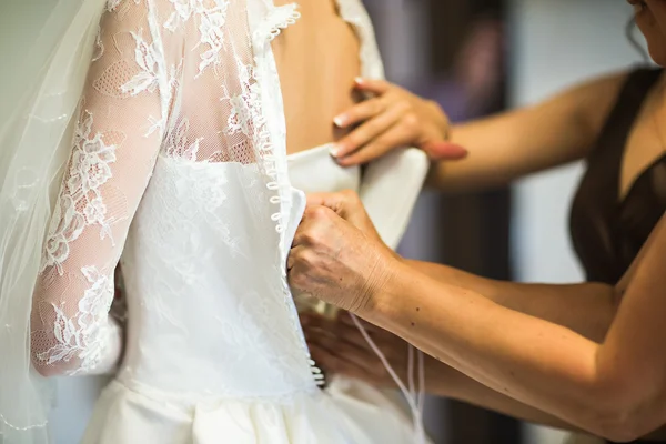 Noivas empregada ajuda noiva no vestido de noiva — Fotografia de Stock