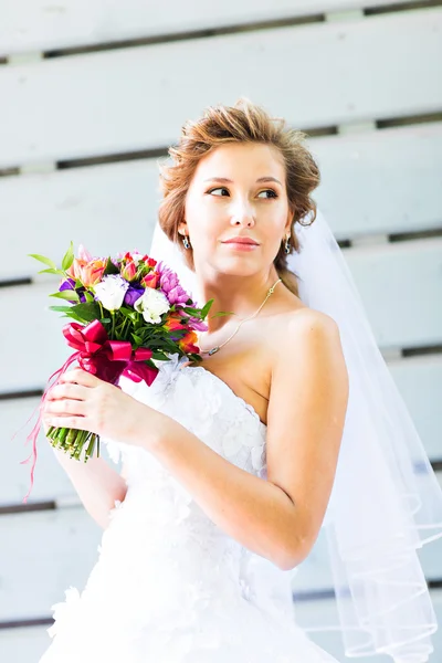 Mooie bruid buitenshuis met bruiloft boeket — Stockfoto