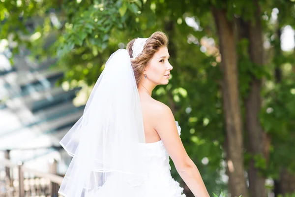 Schöne Braut im Freien mit Brautstrauß — Stockfoto
