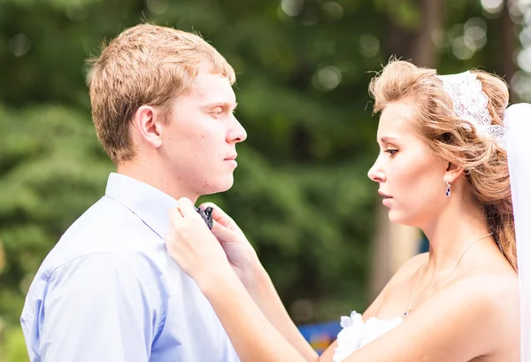 La sposa che fissa l'arco cravatta dello sposo — Foto Stock