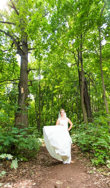 Vestido de noiva acenando em uma floresta — Fotografia de Stock