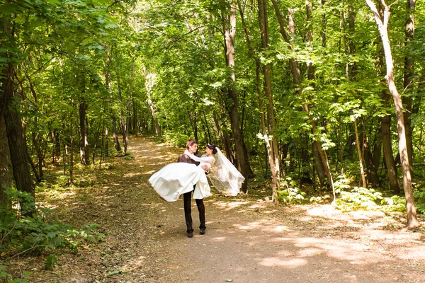 Groom tenant mariée dans ses bras — Photo