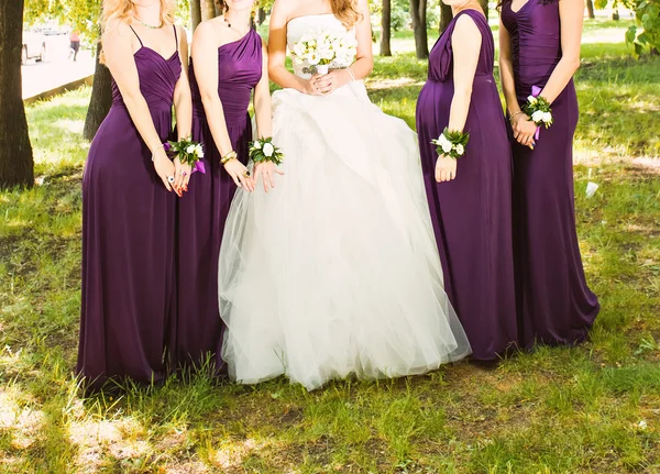 La sposa e le damigelle d'onore stanno mostrando bellissimi fiori sulle loro mani — Foto Stock