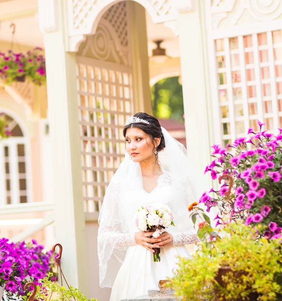 Giovane sposa in abito da sposa tenere bouquet — Foto Stock