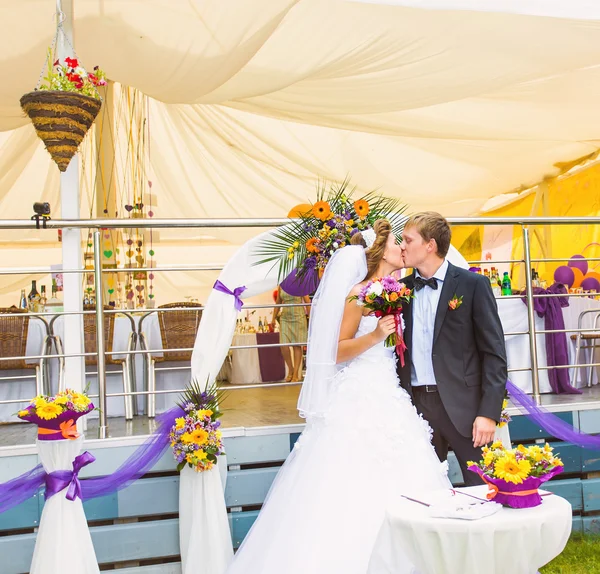 Noiva e noivo beijando em sua cerimônia de casamento — Fotografia de Stock