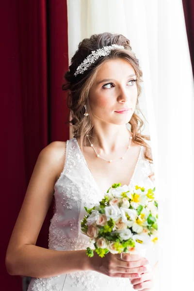 Hermosa novia joven con maquillaje de boda y peinado en el dormitorio — Foto de Stock