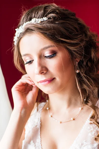 Bela noiva jovem com maquiagem de casamento e penteado no quarto — Fotografia de Stock