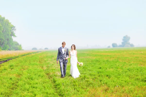 Feliz hermosa novia y novio caminando en el campo —  Fotos de Stock