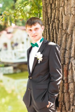 Yakışıklı damat niteliğine takım elbiseli. Erkek portre açık havada