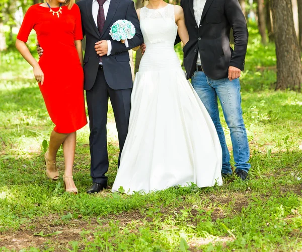 Pasangan pengantin baru dengan tamu di taman hijau yang cerah — Stok Foto