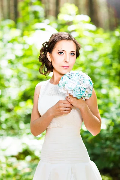 Giovane sposa in abito da sposa tenere bouquet — Foto Stock