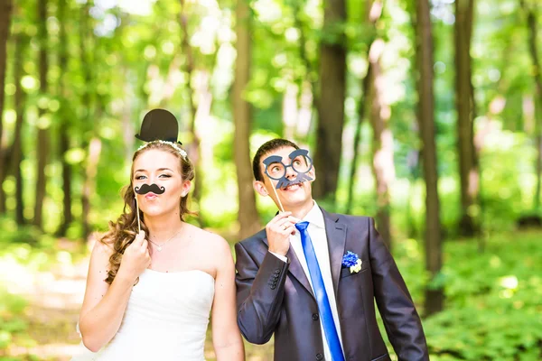 Día de los Inocentes. Boda pareja posando con labios palo, máscara . —  Fotos de Stock