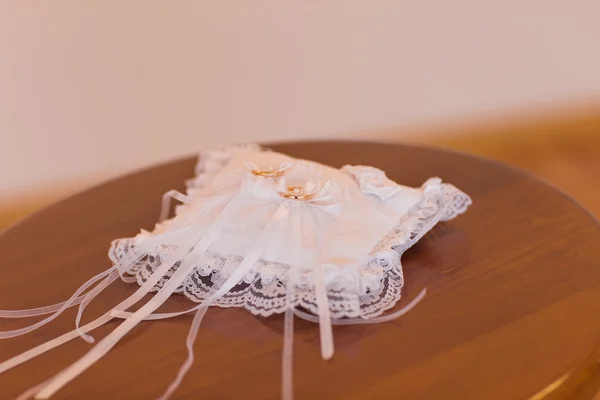 Anillos de boda de oro en el cojín — Foto de Stock