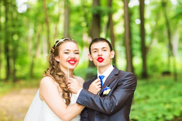 April Fools Day. Matrimonio coppia posa con labbra bastone, maschera . — Foto Stock